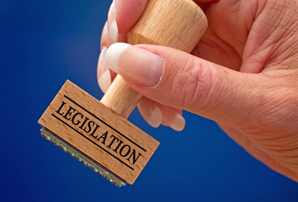 A person holding a rubber stamp with the word legislation on it, relating to climate.