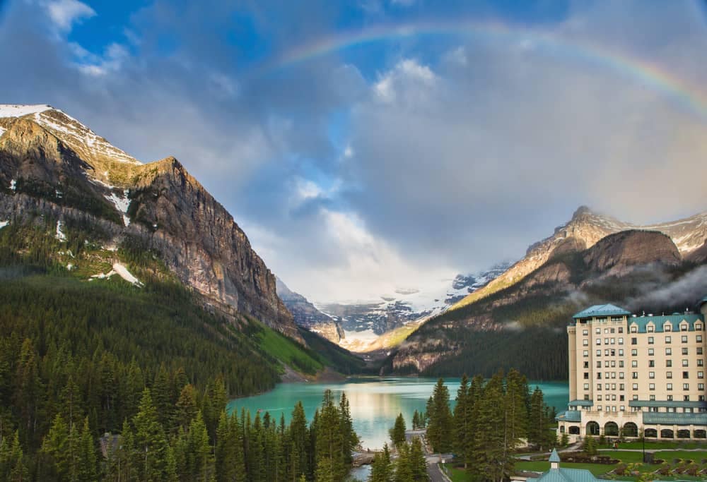 A rainbow is seen over a lake and mountains in Banff, Alberta, protected by Parks Canada.