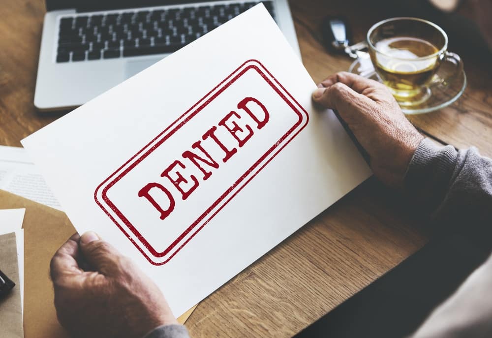 A man holding a paper with the word denied on it at a Glamping Site in Bedwas, foiling plans for expansion.