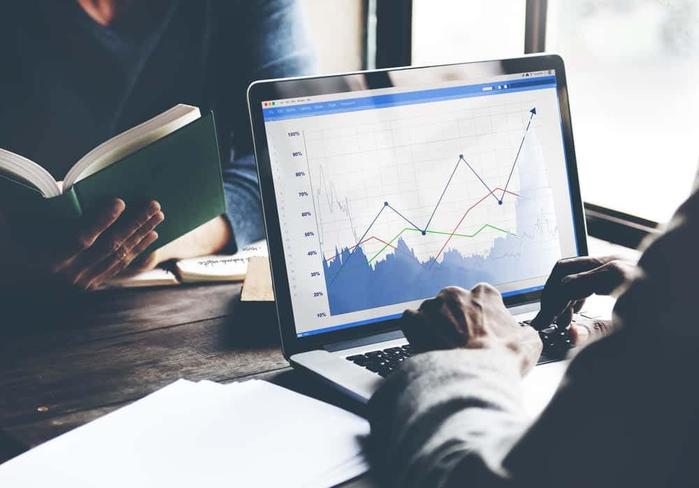 Individuals in the RV industry analyzing graphs on their laptops during the pandemic sales boom.