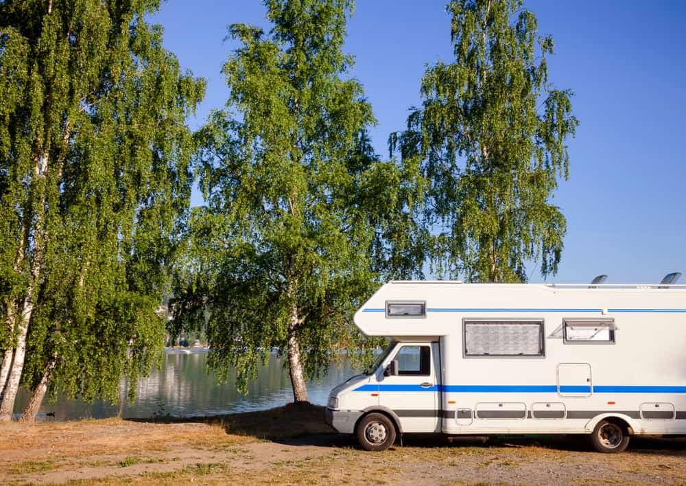 A Colorado Boom RV parked in front of a lake.