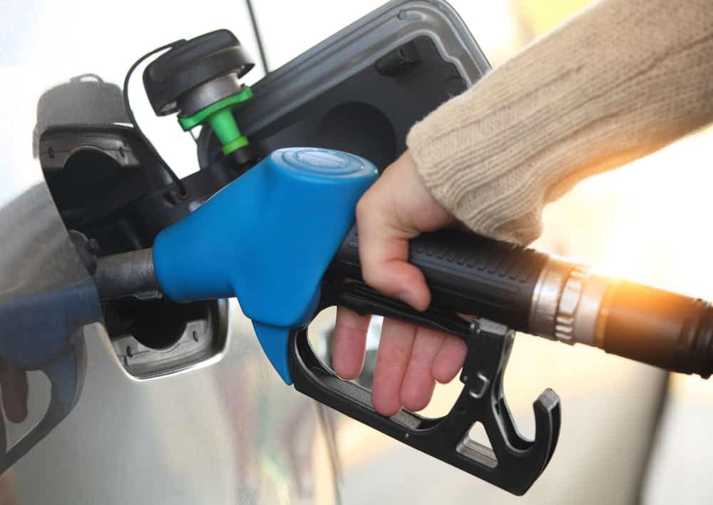 A driver is fueling up their car amidst rising gas prices.