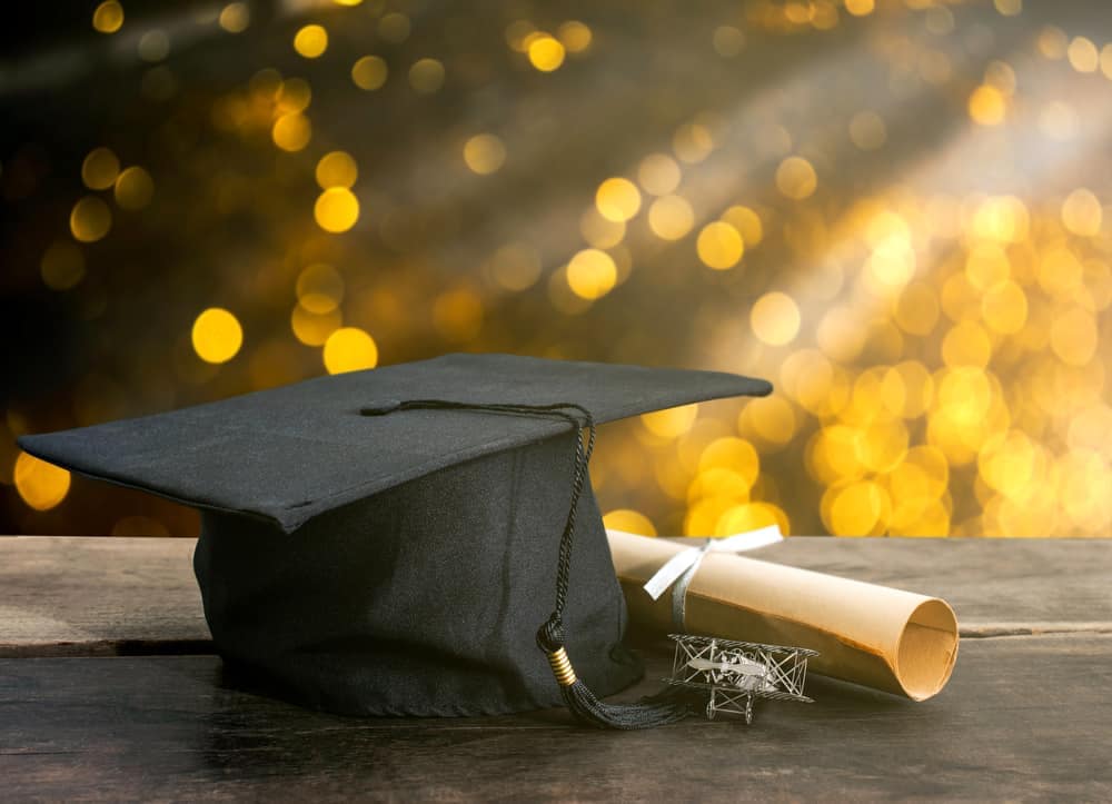 A graduation cap and diploma on a wooden table in Europe.