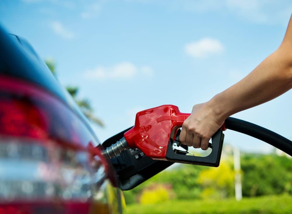 A woman is pumping gas into her car