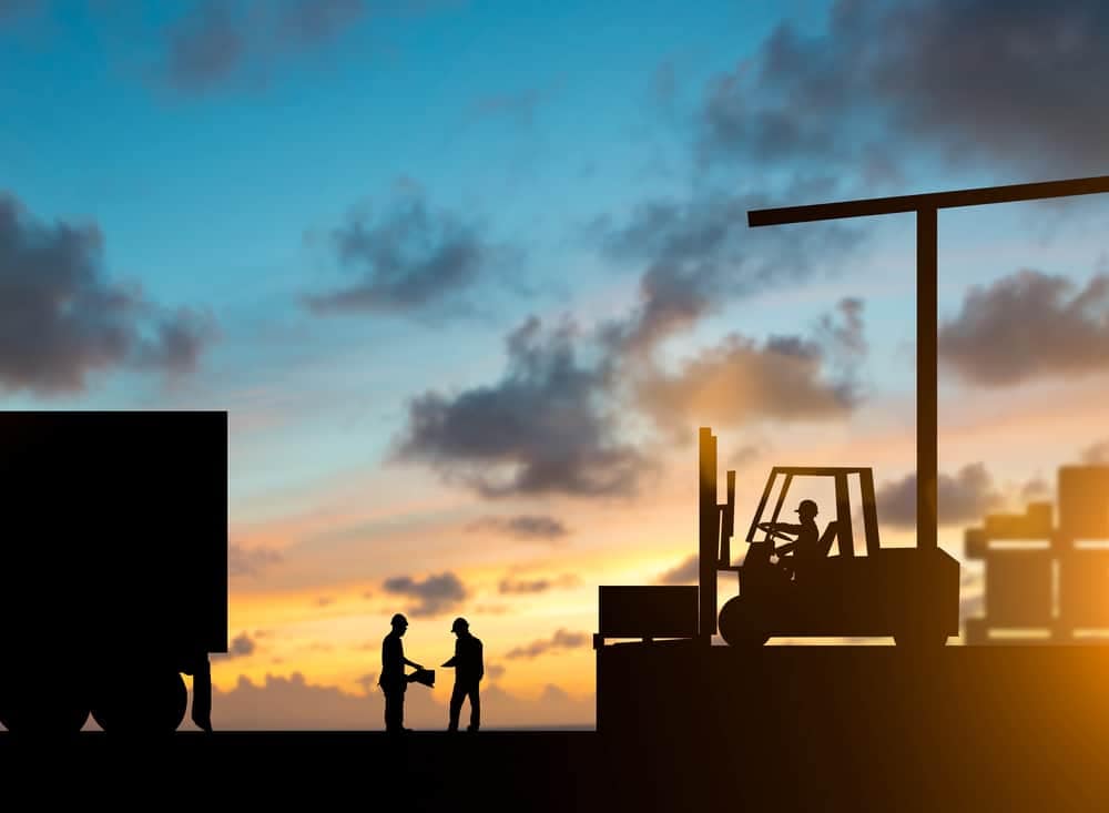 A forklift truck and a man standing next to it at sunset, symbolizing the softening of the supply-chain relief.