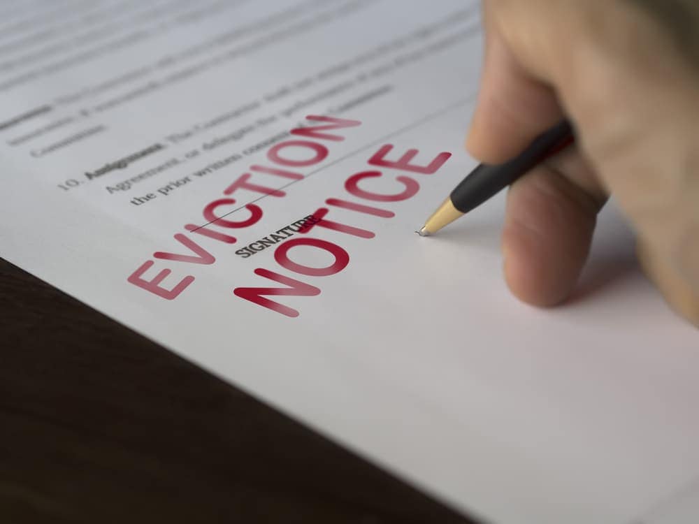 An RV tenant in Georgia signing an eviction notice on a piece of paper.