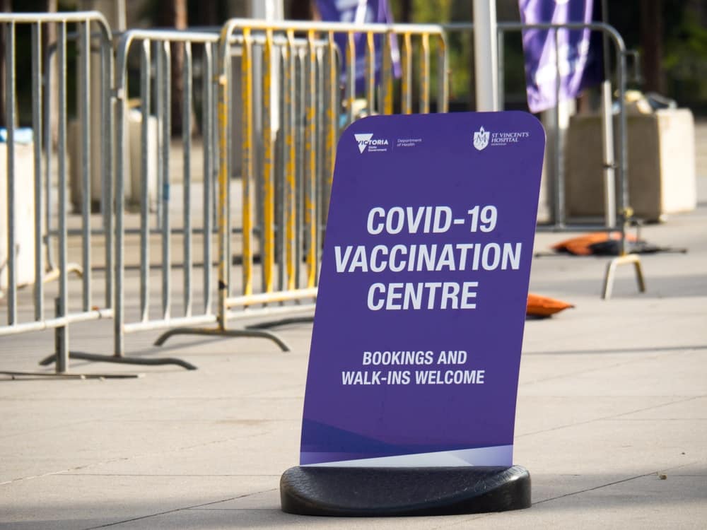 A Premier-authorized covid-19 vaccination centre sign in front of a fence in Western Australia.