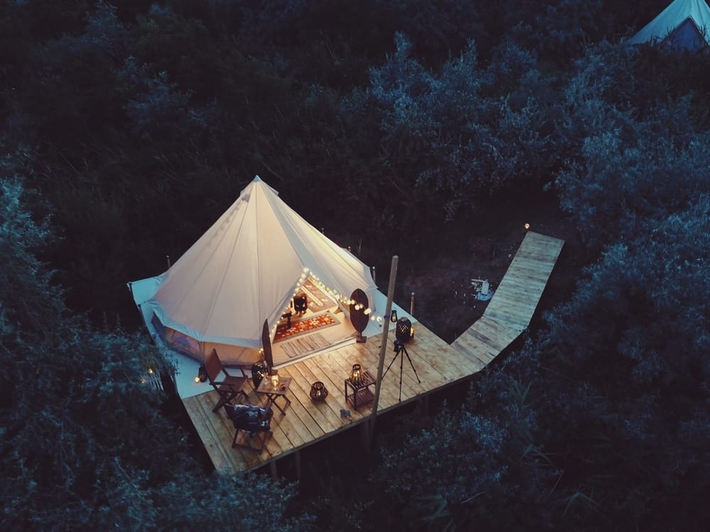 A fancy camping experience in Alabama's serene woods, offering a unique aerial view of a tent.