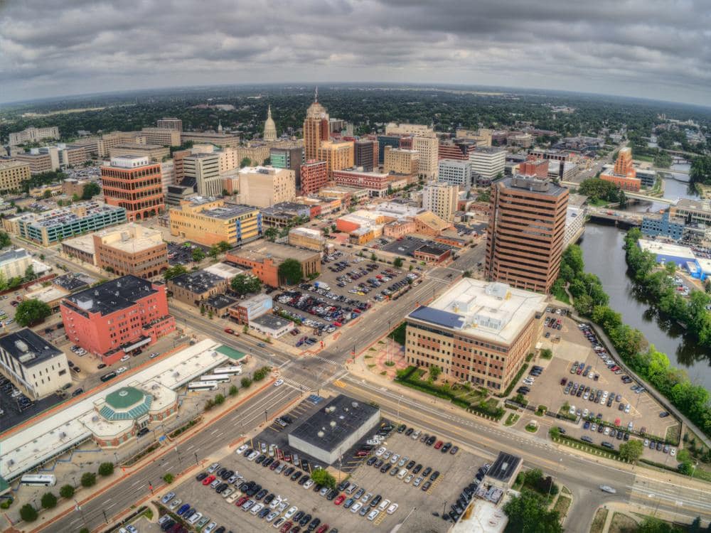 An aerial view of Lansing, a city with buildings and a river.
