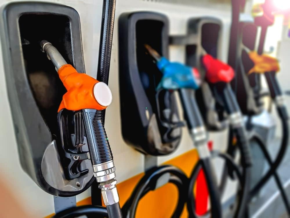 A group of gas pumps with nozzles in different colors, providing options to customers to purchase fuel at varying gas prices.