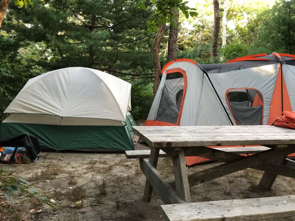 Two tents set up in a Rhode Island campground during camping season.