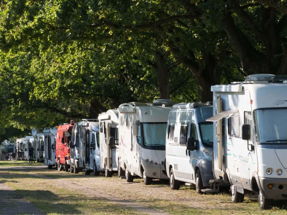 Griffith Caravan Exhibition showcases a picturesque row of RVs parked in a serene wooded area.
