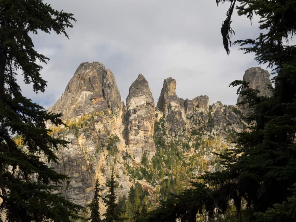 Three rock formations in a National Forest with trees in the background.