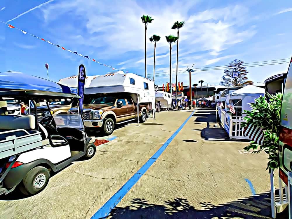 A rv is parked next to a golf cart in a parking lot at the Tampa Bay Summer RV Show.