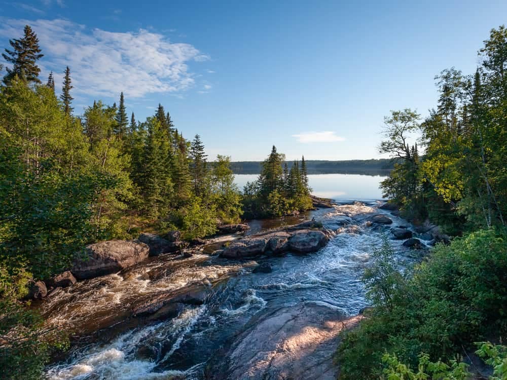 This description showcases a scenic river with lush trees and rugged rocks. Additionally, it offers free park access for visitors.