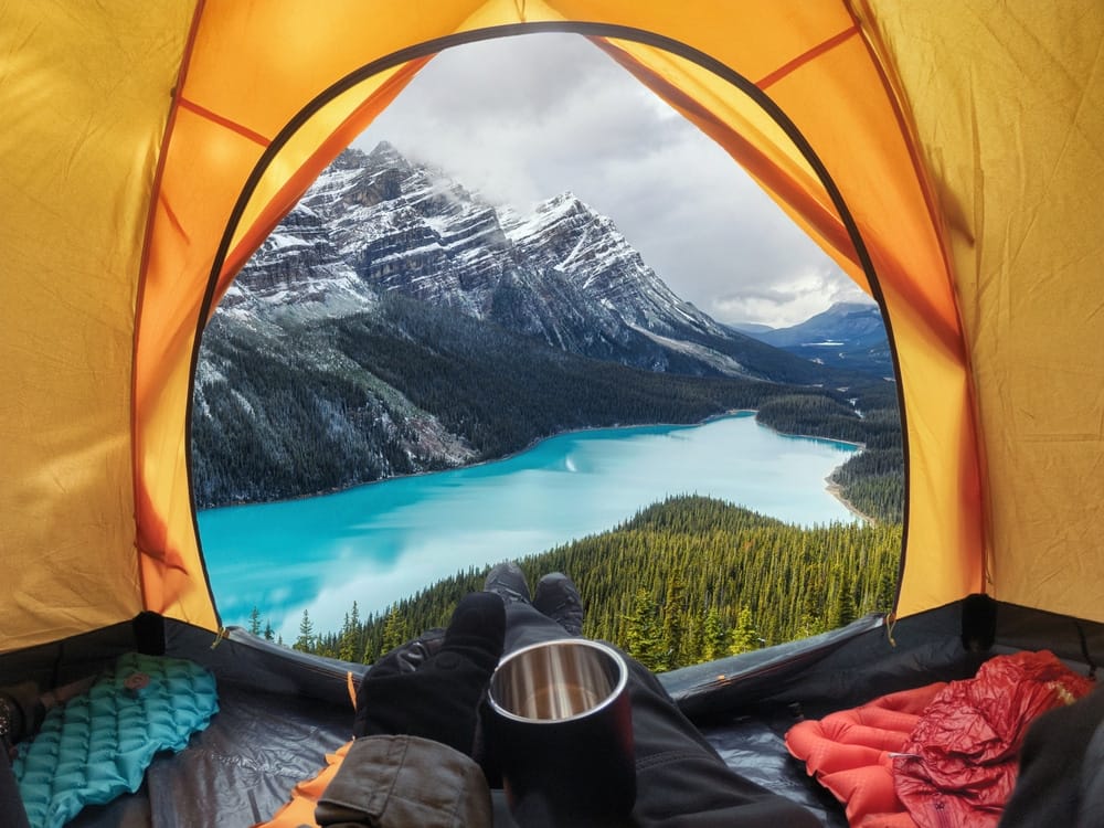 Young Canadian campers sit in a tent with a view of a lake during the 2022 survey.