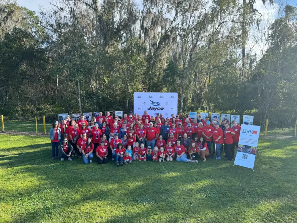 A group of RVers in red shirts posing for a photo.