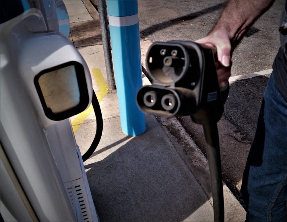A man is charging his electric car at a charging station for recreational vehicles.