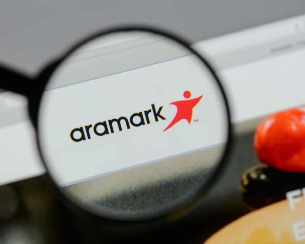 A magnifying glass is placed over the Aramark logo.