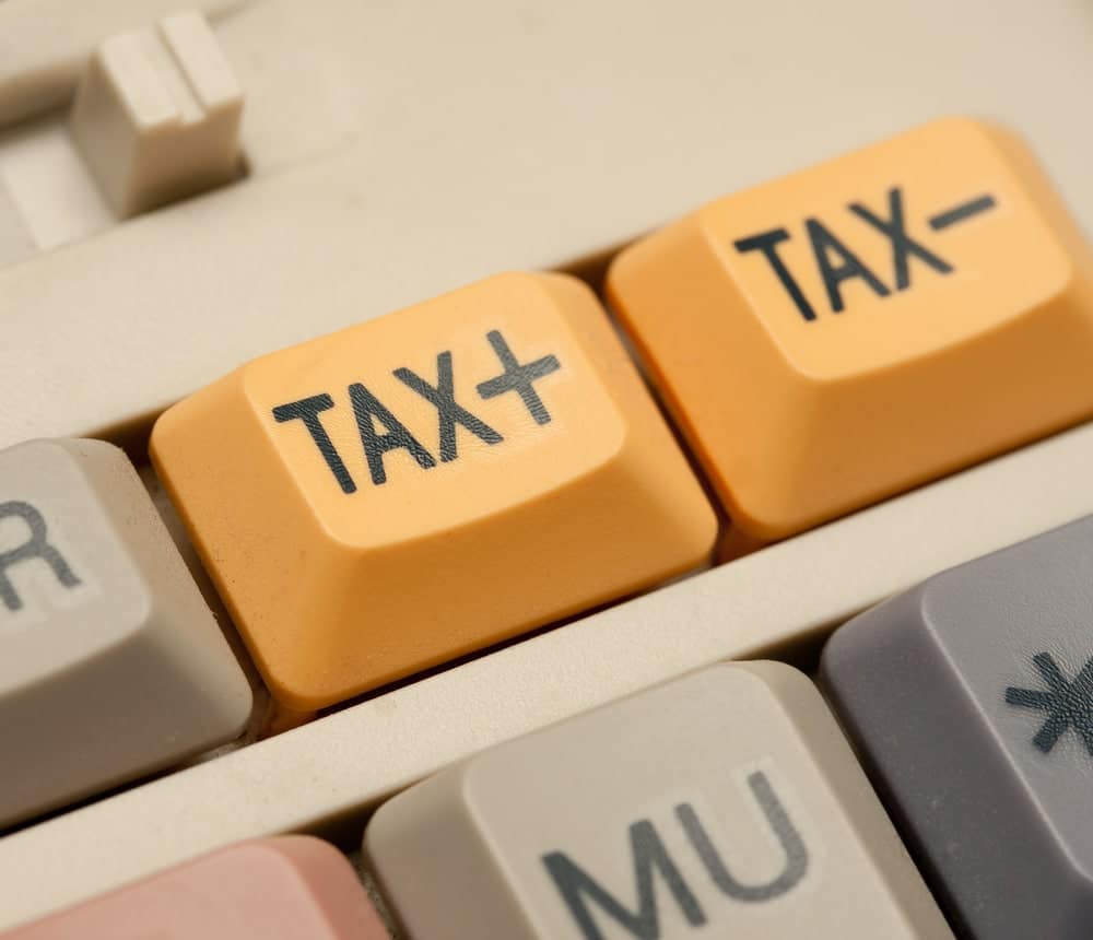 A computer keyboard with the word tax on it, reminding users of sales tax and potential upgrades.