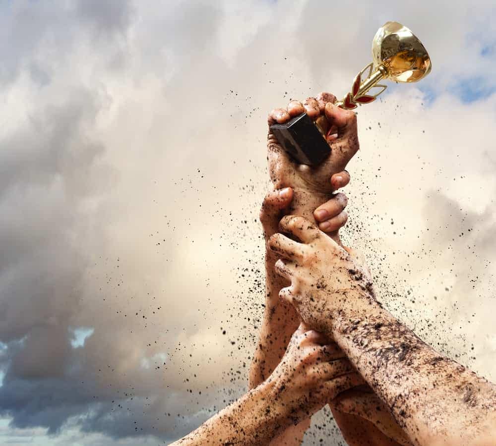 A group of hands holding a trophy at a glamping site.