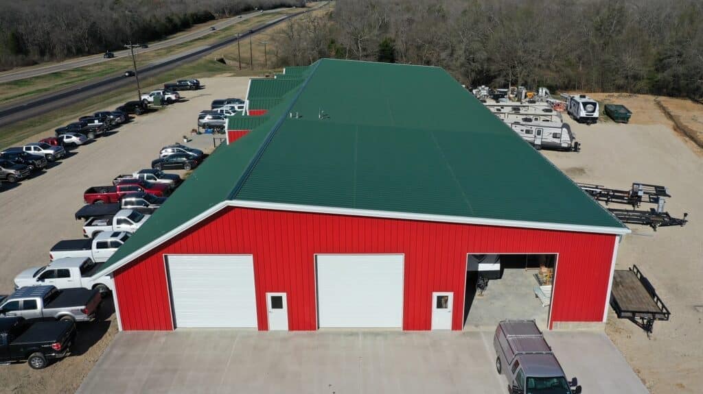 An aerial view of a red barn with parked cars, showcasing a 5,000-square-foot addition.