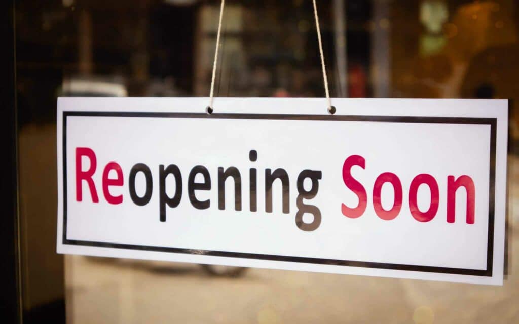 A sign that says Skenes Creek Campground reopening soon hanging from a window.