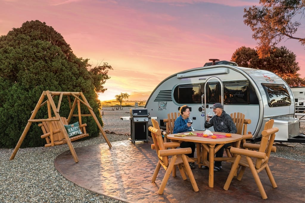 Two people sitting at a table in front of an airstream rv at the Willcox/Cochise KOA Holiday.