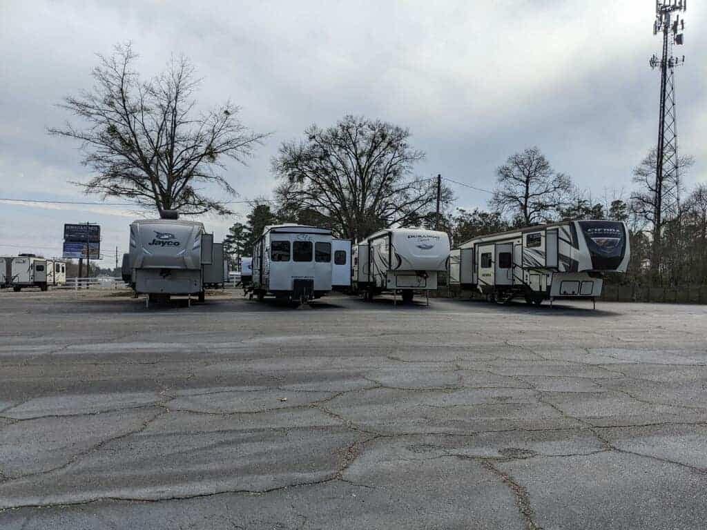 A group of Hayes RVs, under new ownership, parked in a parking lot.
