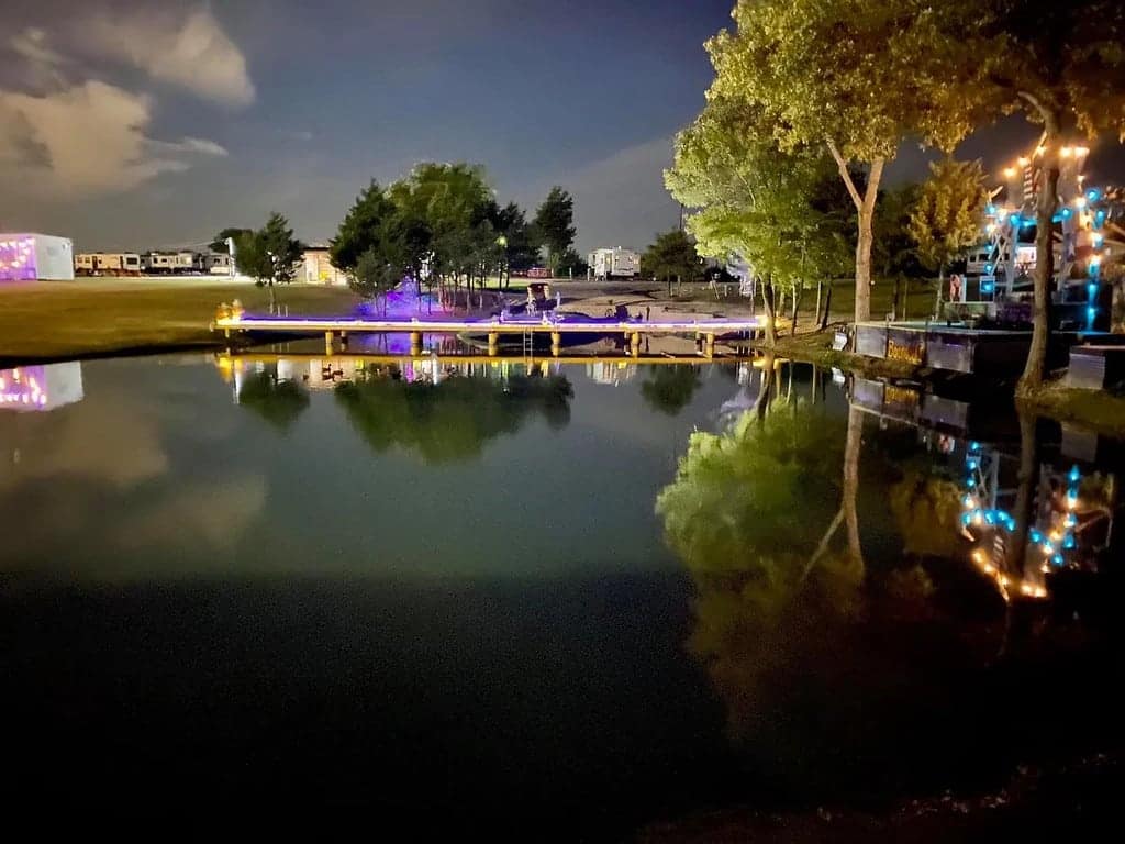 A serene night scene featuring a pond in the background at Lakeland RV Ranch, the Park of the Year, where magical transformations unfold.