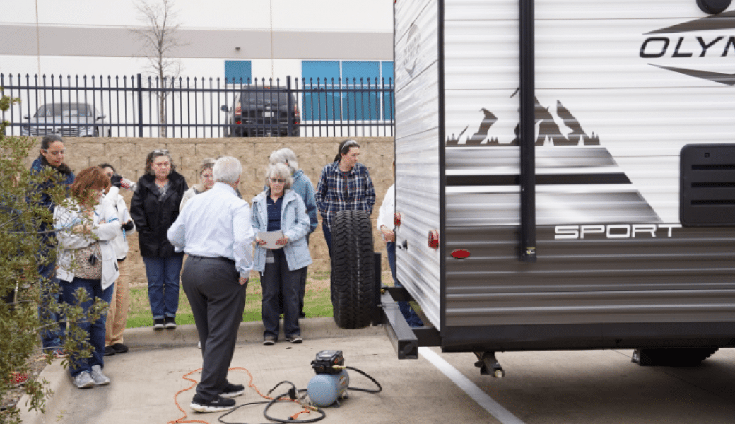 Sponsors and an All-Female Tech Class gather around a General RV Center.