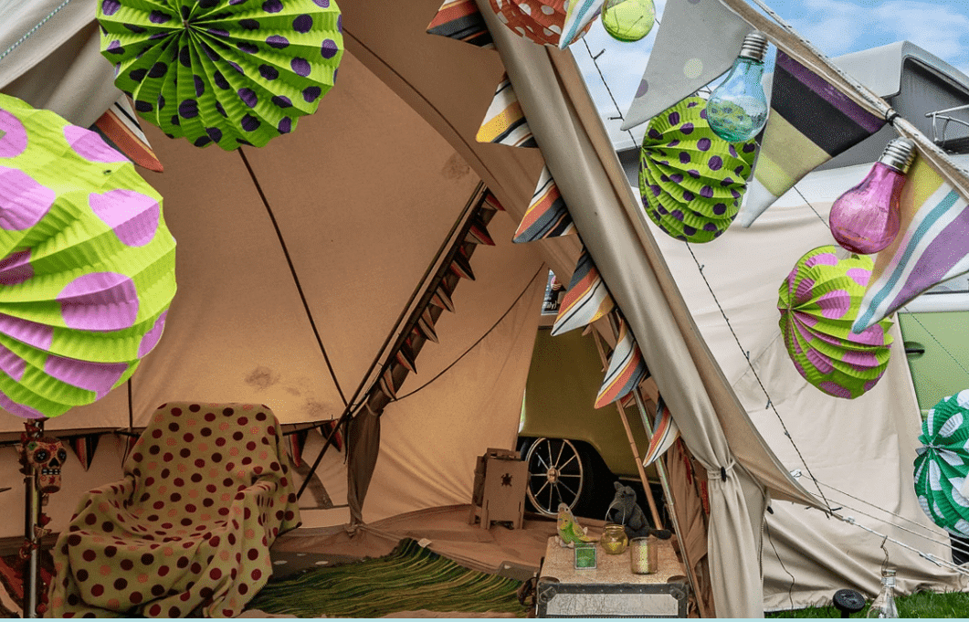 A couple's glamping tent in Harrogate adorned with colorful paper lanterns hanging from it.