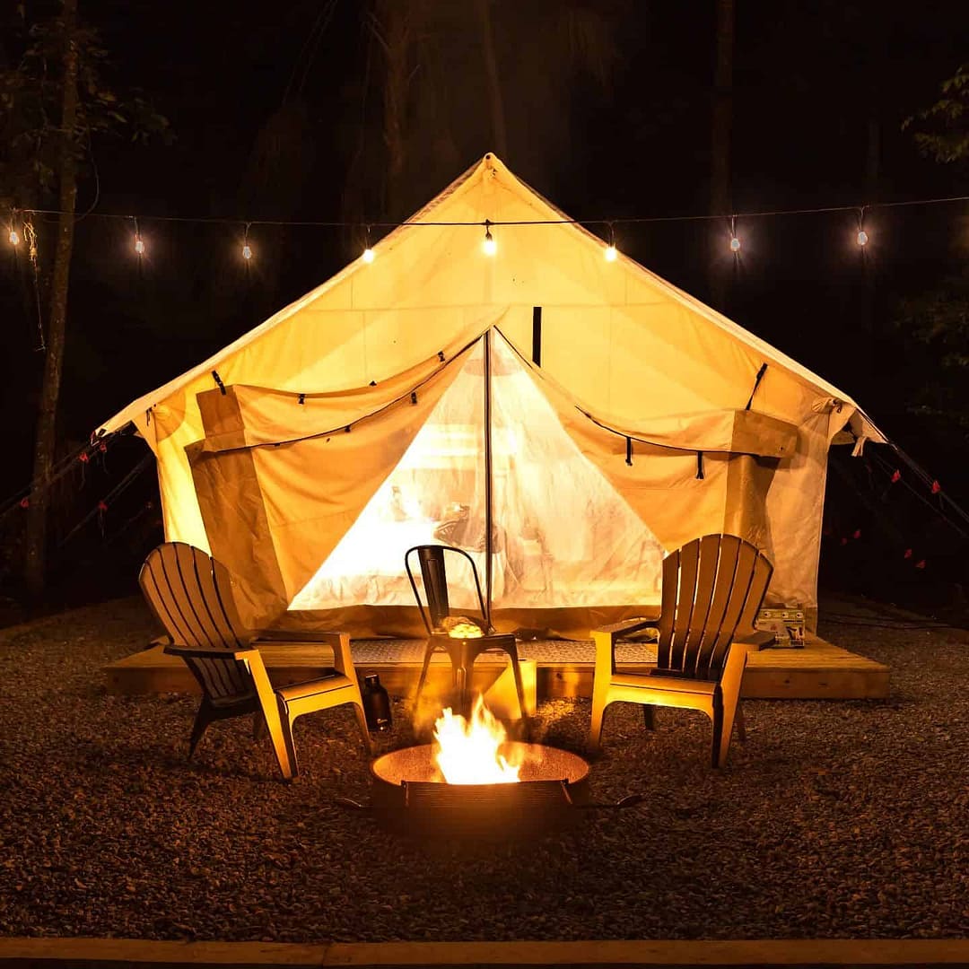 A glamping tent with chairs and a fire pit at Hillsborough River State Park.