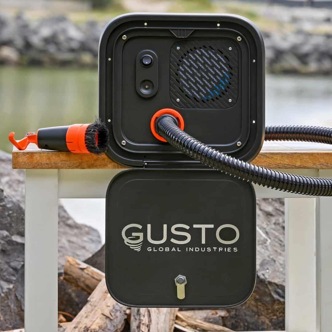 The Gusto Global portable fire pit is sitting on a bench next to a body of water, perfect for RV Owners looking to relax and enjoy the outdoors.