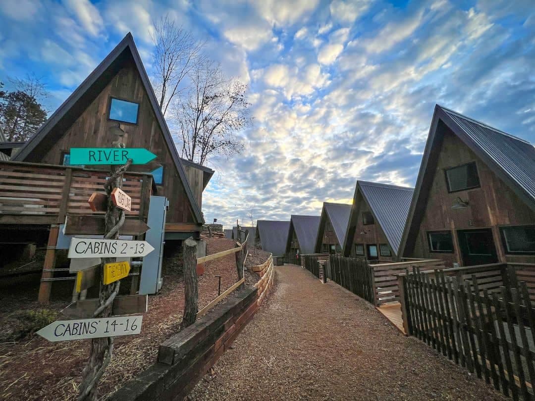 A Scandinavian Experience awaits at the New A-Frame Campground in North Carolina, where a group of cabins with signs on the side of the road invite you to indulge in cozy retreats surrounded