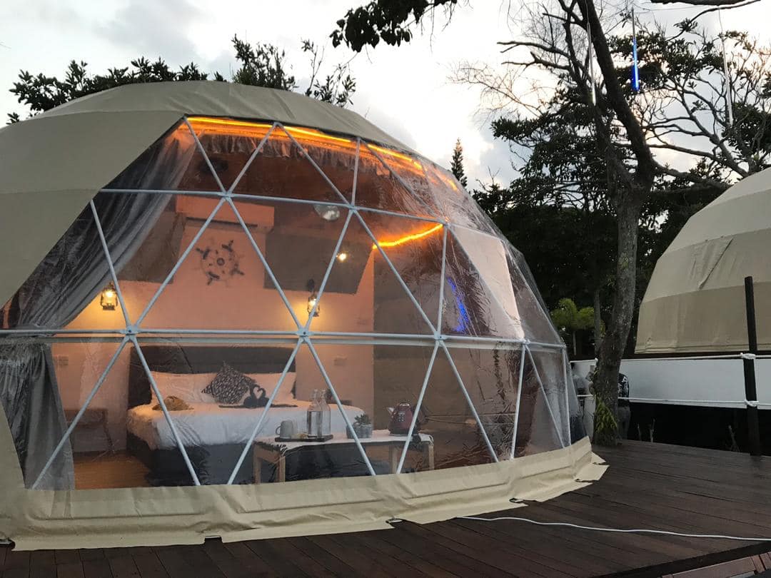 Two dome tents sitting on top of a wooden deck at the Cliffside Glamping, offering stunning Sea Views at the Sea Horizon Resort.