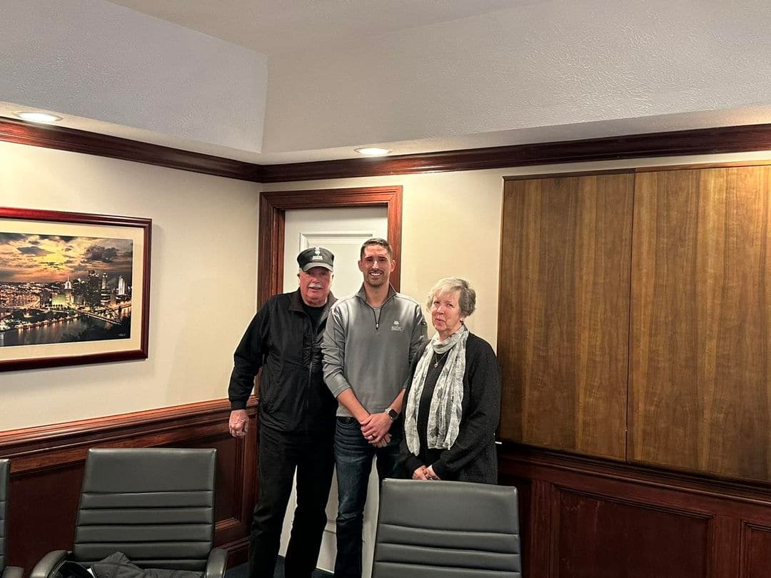 Two men and a woman, representing the new generation of owners, standing in a conference room.