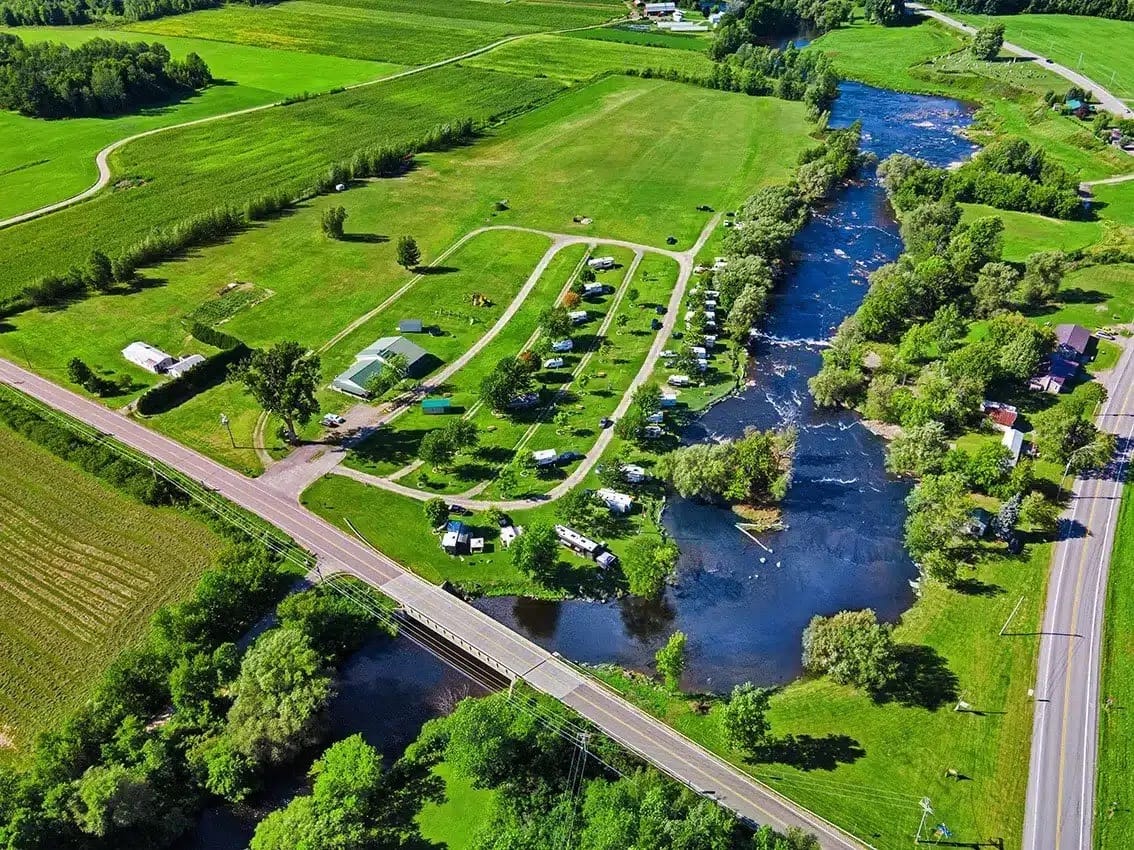 An aerial view of a riverside camping area and a babbling brook.