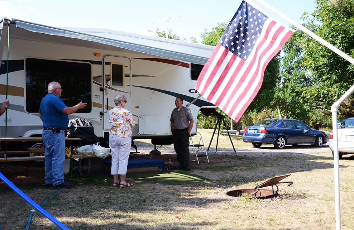 A group of people standing in front of an RV at a campground near Lake Ashtabula.