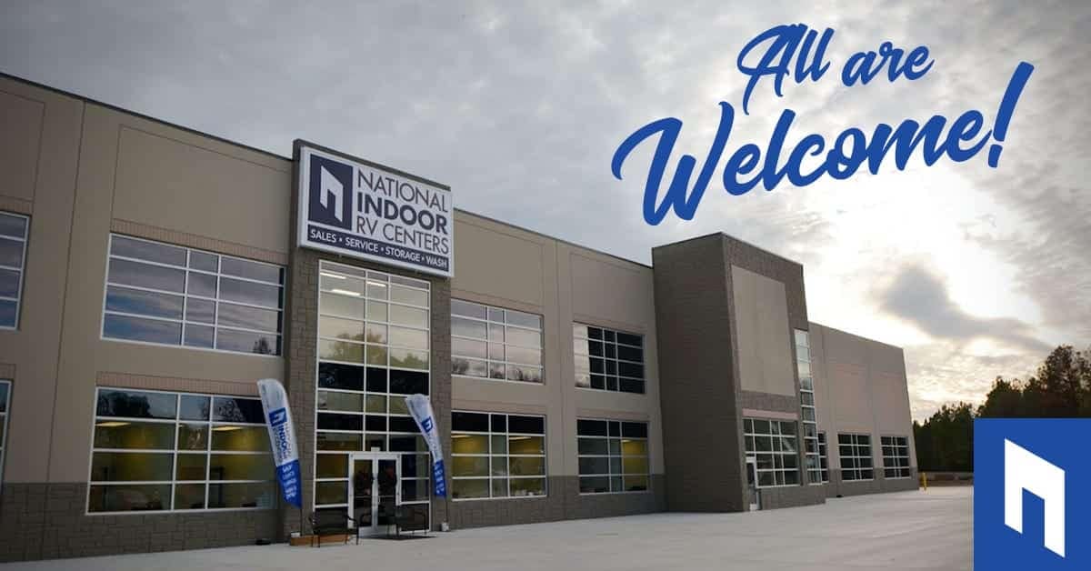 A National Indoor RV Centers building with a sign that says all are welcome.