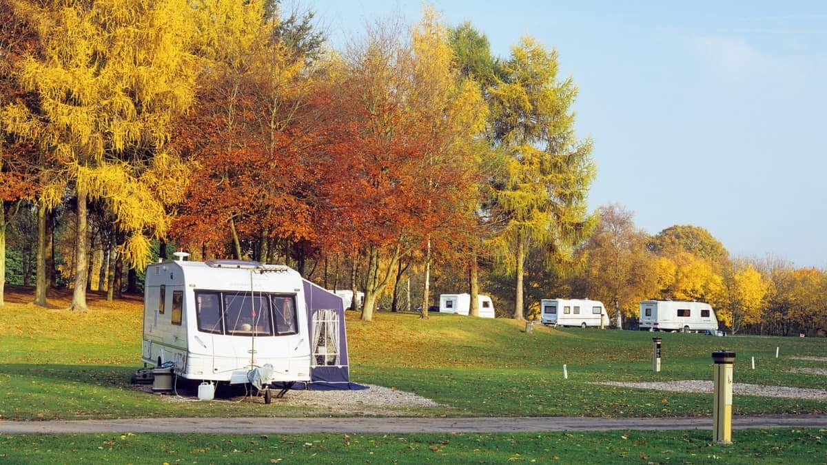 A group of UK rvs parked on a grassy field, creating a sustainable glamping site that aims to reduce environmental impact.