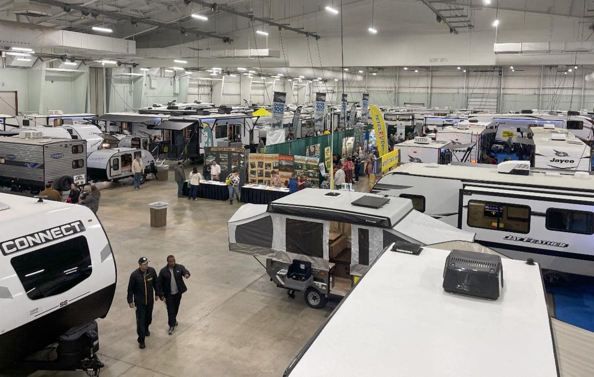 York RV Show featuring various models of recreational vehicles and vendor booths, with visitors and exhibitors walking around, designed to impress.