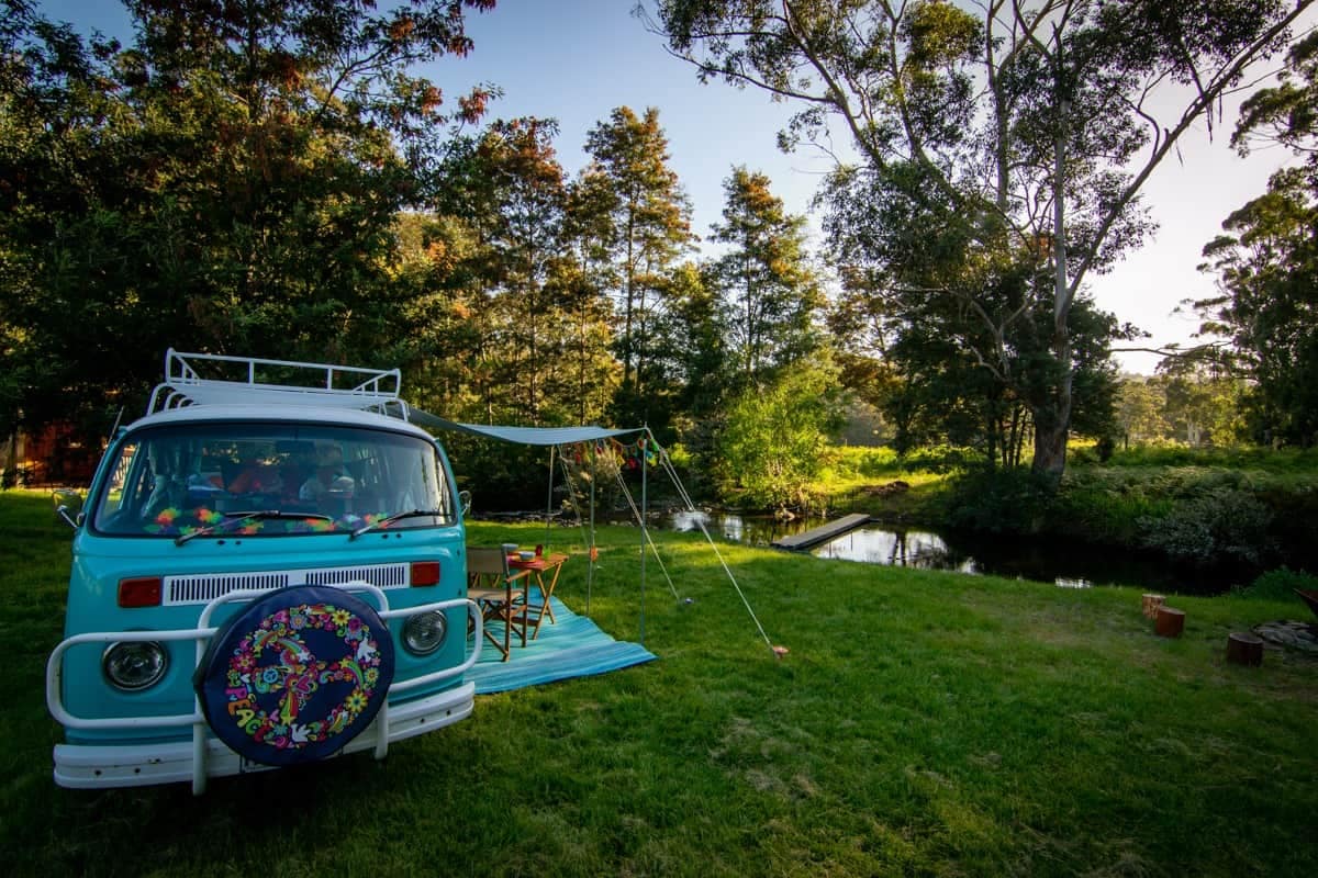 A Kombi-Based vw camper van parked in a grassy area in Tasmania, providing luxury glamping accommodation.