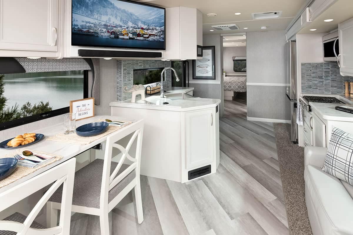 Experience the spacious interior of a Fleetwood RV, complete with a modern kitchen and cozy dining area.
