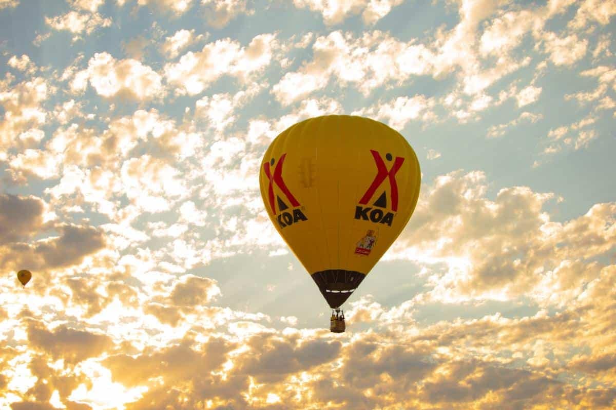 Balloon Fiesta featuring hot air balloons flying in the sky at sunset.