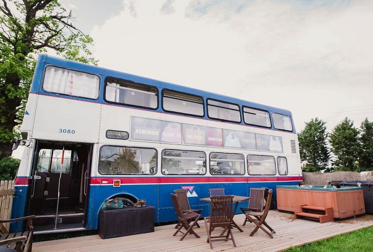 A unique countryside retreat that offers the experience of staying in a double decker bus on a wooden deck.