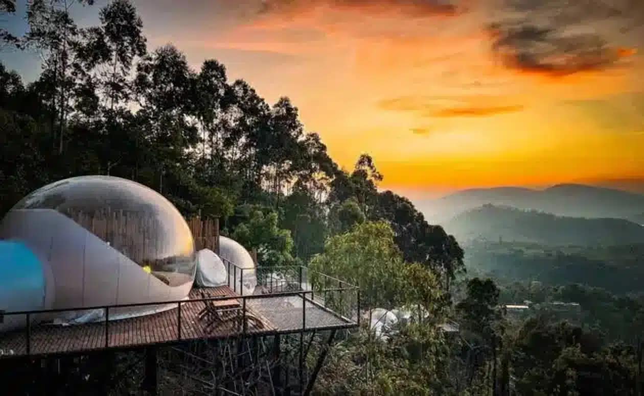 A glass dome sitting on top of a hill overlooking the mountains in India, providing a unique glamping experience known as Bubble Glamping.