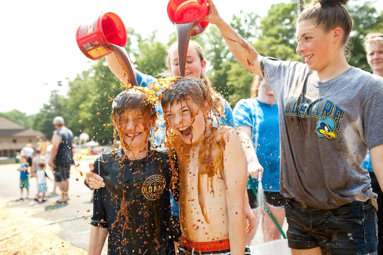 A group of children enjoying World Chocolate Day activities and playing in the mud at Jellystone Park locations.