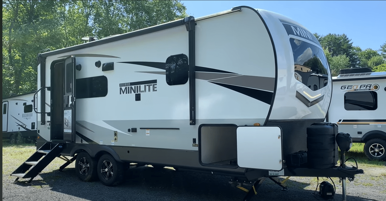 A white and black 2023 Rockwood Mini Lite 2205S parked in a lot.