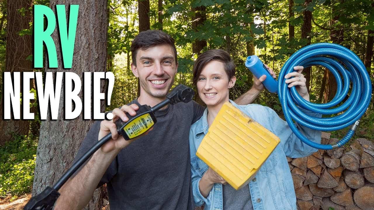 Two RV newbies holding a hose, seeking tips as new owners.